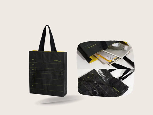 Black washable paper tote bag with water droplets showing its washable and durable surface
