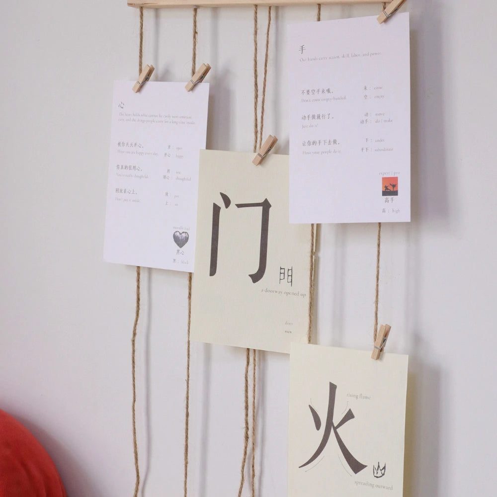 Chinese character learning cards displayed on a wall with clips.