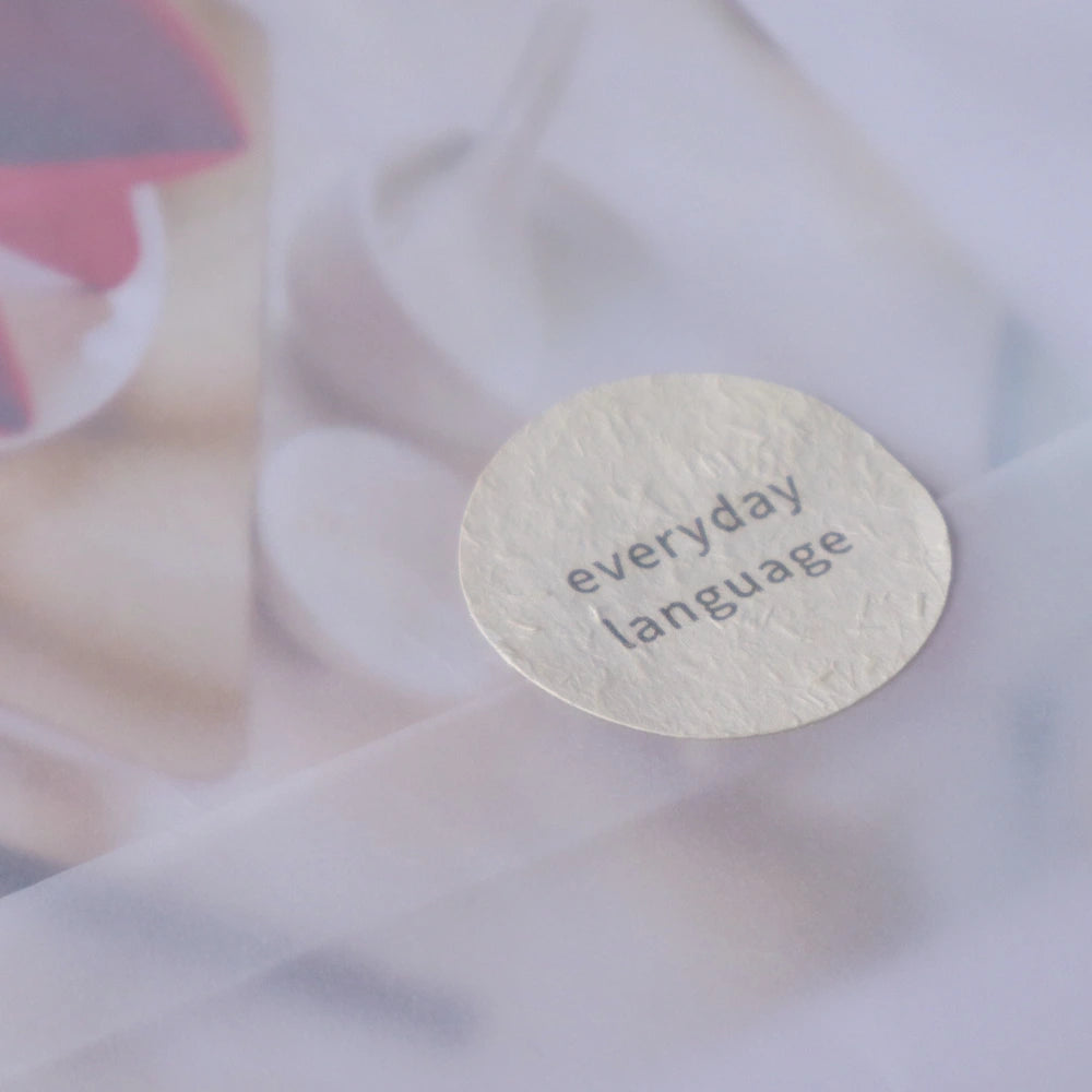 Language learning pages presented with earth-tone paper labels as part of a paper-based visual system