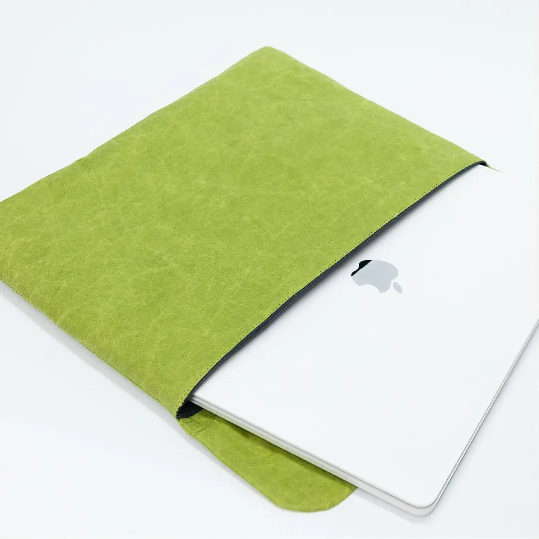 Green washable paper laptop sleeve holding a MacBook.
